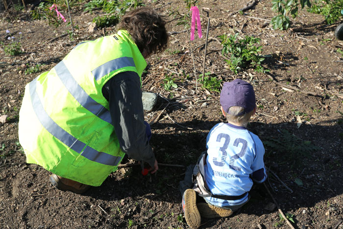 Moreton Bay Regional Council Bushcare officer Wendy Heath teaches a young volunteer how to remove weeds by hand